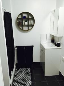 a bathroom with a black and white tile floor and a mirror at Cottage on Cork Steadman Cottage in Winton +19 photos