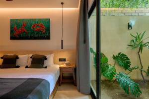 a bedroom with a bed and a painting on the wall at Hotel Compartir in Brisas de Zicatela +47 photos