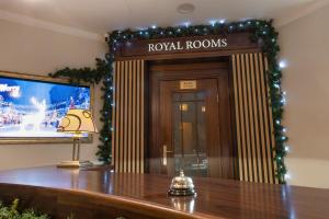 a hotel lobby with a royal rooms sign and a table at Royal Rooms Self Check-in in Poznań