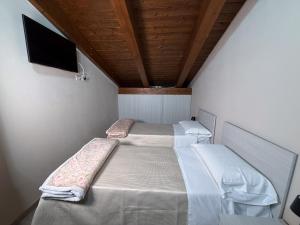 two beds in a room with a flat screen tv at La Dimora Certosina in Padula