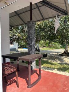 a picnic table and a bench under a pavilion at Azriel marari in Mararikulam