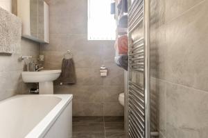 a bathroom with a tub and a sink and a toilet at Cosy Brierfield house with fireplace and parking in Brierfield