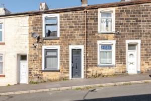 a brick building with white windows and a door at Cosy Brierfield house with fireplace and parking in Brierfield