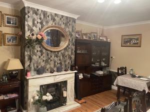 a living room with a fireplace and a mirror at Barrow View Accommodation in Mountmellick