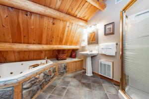 a bathroom with a tub and a sink at Viva By The Stream by Railey Vacations in McHenry