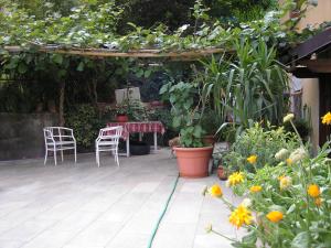 a patio with a table and chairs and plants at Il Giuggiolo in Calco