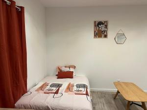 a small bedroom with a bed and a table at Agreable studio proche du circuit du Mans in Arnage