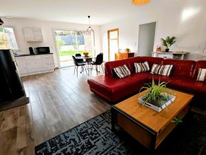 a living room with a red couch and a table at Tamaris Abba in Talmont