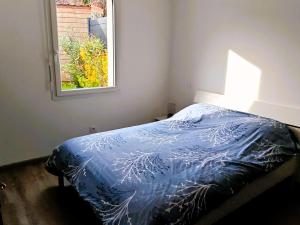 a bedroom with a blue bed with a window at Tamaris Abba in Talmont