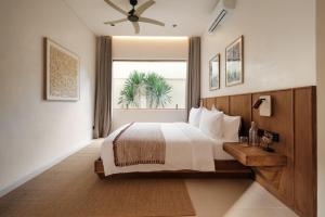 a bedroom with a large bed and a window at Manu Villas in Sanur +26 photos