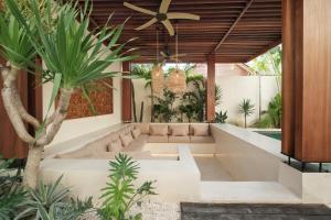 a living room with a couch and a ceiling fan at Manu Villas in Sanur