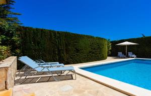 a swimming pool with a chair and an umbrella at Ca Nostra in Cala Millor