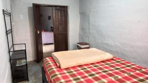 a bedroom with a bed with a blanket on it at Casa turística la Nativa in Puracé