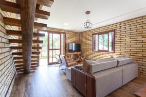 a living room with a couch and a tv at Casa de veraneio na Itapeva in Torres