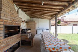 a kitchen with a long table with chairs and a counter at Casa de veraneio na Itapeva in Torres