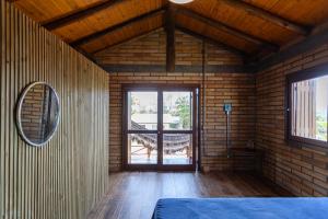a room with a large window in a wooden house at Casa de veraneio na Itapeva in Torres