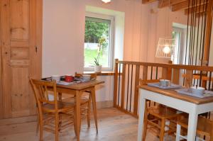 a dining room with a table and chairs and a window at Joz Une Halte in Saint-Antoine