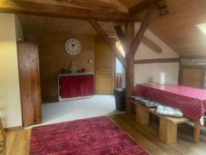 a living room with a red couch and a clock at Gite l'Ancolie in Marignier