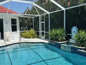 a swimming pool with a pergola next to a house at Villa Paloma in Cape Coral