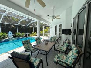 a patio with a table and chairs next to a pool at Villa Paloma in Cape Coral