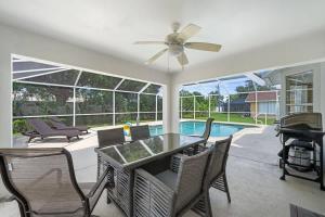 a dining room with a table and chairs and a pool at Villa Yvonne in Cape Coral +14 photos