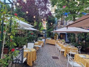 an outdoor restaurant with tables and chairs and umbrellas at Hotel Derby in Bellaria-Igea Marina
