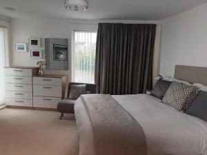 a bedroom with a bed and a dresser and a window at Seaview West Coast - Exceptional - 2 Bedrooms Sleeps 5 -Stunning Sea Views - 500 metres to Beach in Bournemouth