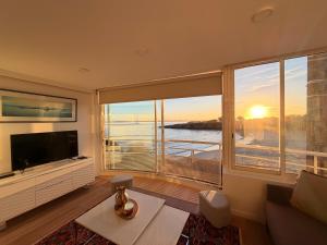 a living room with a large window and a television at Le Baloo vue sur mer in Ploemeur