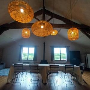 a room with a table and chairs and chandeliers at La Lumière Dorée in Lauzerte