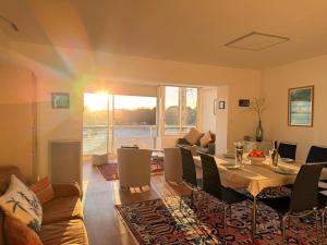 a living room with a dining table and a living room with a couch at Le Baloo vue sur mer in Ploemeur