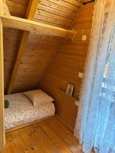 a room with a bed in a wooden house at Planinski šapat in Blidinje