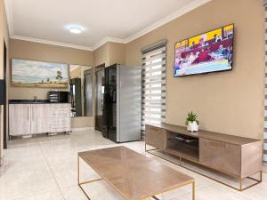 a living room with a tv on the wall at Dunamis Lodge in Giyani