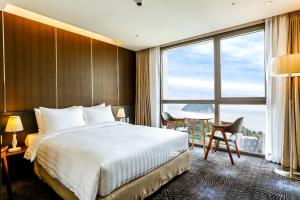 Golden Daisy Hotel في سيوجويبو: غرفة فندقية بسرير ونافذة كبيرة