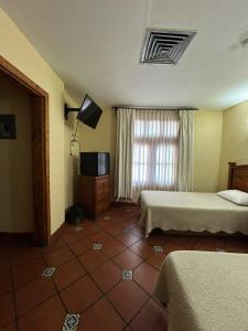 a hotel room with two beds and a television at HOTEL COLONIAL MATAMOROS in Matamoros