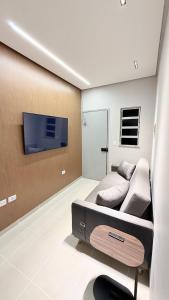 a room with a bed and a tv on a wall at Luxuoso Apartamento 2 quartos no Centro in Imperatriz