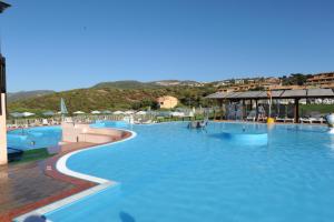 a large swimming pool with blue water in a resort at Aquafantasy rooms in Isola Rossa