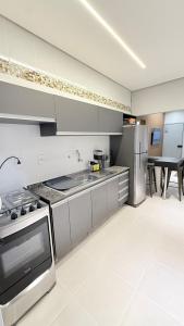 a kitchen with stainless steel appliances and a table at Luxuoso Apartamento 2 quartos no Centro in Imperatriz