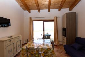 a living room with a table and a couch at Aquafantasy rooms in Isola Rossa