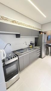 a kitchen with a stove and a refrigerator at Luxuoso Apartamento 2 quartos no Centro in Imperatriz +9 photos