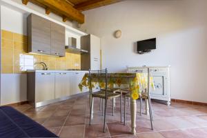 a kitchen with a table and chairs in a room at Aquafantasy rooms in Isola Rossa