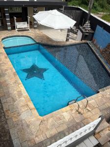 a swimming pool with a star in the middle at Casa praia e piscina in Bertioga