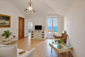 a living room with a couch and a table and a television at Parasio - Mareri apartments in Imperia