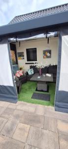 a screened in patio with a couch and a tv at Appartement Ons Plekje in De Wilp