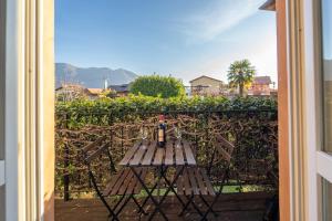 a bottle of wine sitting on a bench in front of a hedge at Bright apartment with private garage in Cernobbio