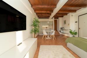 a bedroom with a flat screen tv and a living room at Bright apartment with private garage in Cernobbio