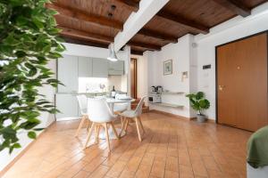 a kitchen with white cabinets and a table and chairs at Bright apartment with private garage in Cernobbio