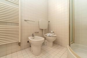 a bathroom with a toilet and a sink and a tub at Bright apartment with private garage in Cernobbio +29 photos