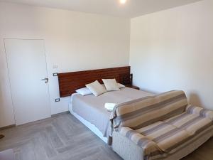 a bedroom with a bed with a wooden headboard at B&B Zvana's - Da Giovanna in Imola