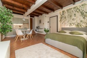 a bedroom with a large bed and a kitchen at Bright apartment with private garage in Cernobbio