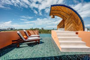 a resort with a pool and a chair and stairs at Coco Lou - Private Villa with Rooftop Pool in Holbox Island +34 photos